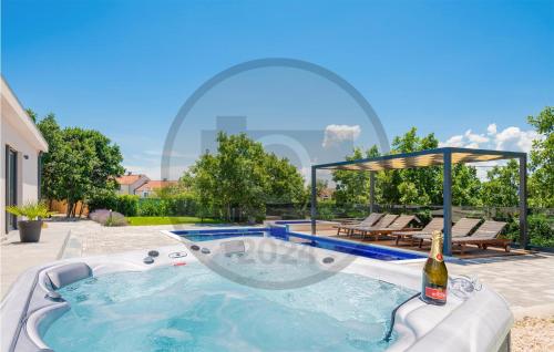 een hot tub in de achtertuin met een fles wijn bij Gorgeous Home In Glavina Gornja in Gornja Glavina