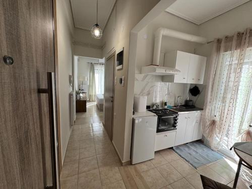 a kitchen with white cabinets and a stove in it at Evann's sweet home in Larisa