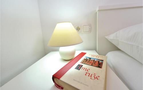 a lamp and a book on a table next to a bed at Apartment Vrsi-Mulo 02 in Kod Mula