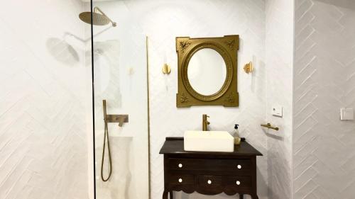 Un baño con un lavabo y un espejo en la pared. en Suites Plaza Alta, en Algeciras