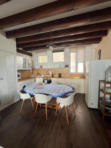 une cuisine avec une table et des chaises dans une cuisine dans l'établissement Maison de ville centre Arcachon, à Arcachon