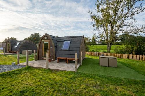 a tiny house in a yard with a wooden deck at Borrett Escapes - Luxury Pods in Sedbergh