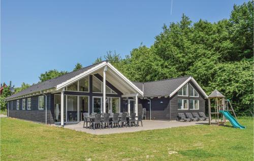 a log cabin with chairs and a playground at Holiday Home Kronens Have Tranekær Vi in Hou