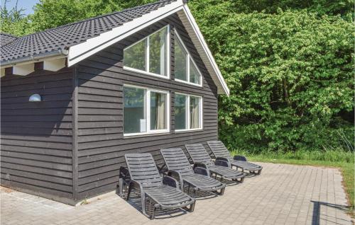 a group of chairs sitting on the side of a house at Holiday Home Kronens Have Tranekær Vi in Hou