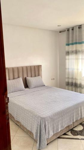 a bedroom with a large bed with two pillows at Appartement City Agadir 2 in Agadir