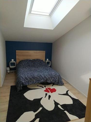 une chambre avec un lit et un tapis au sol dans l'établissement appartement neuf au calme, à Sainte-Croix