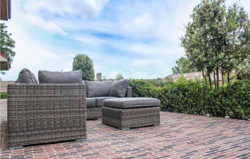 two wicker chairs and a couch on a brick patio at Awesome Home In Diksmuide in Diksmuide