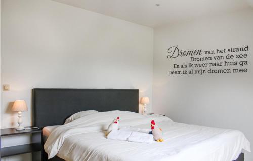 two stuffed animals are sitting on a bed at Awesome Home In Diksmuide in Diksmuide