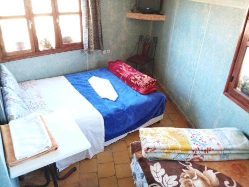 a small room with a bed and a couch at Auberge Restaurant Rooftop Tamazirt in Boumalne