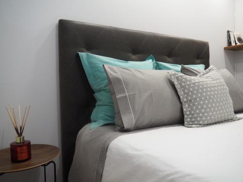 a bed with a black headboard and some pillows at Camacho Residence in Funchal