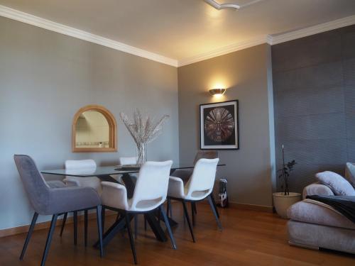 a dining room with a table and white chairs at Camacho Residence in Funchal