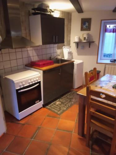 une cuisine avec une cuisinière et un comptoir dans l'établissement Hemery, à Picherande