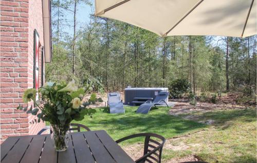 a patio with a table and an umbrella and a grill at Achtermars in Ommen