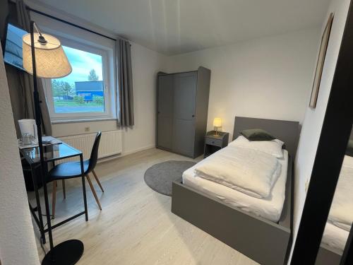 a bedroom with a bed and a desk and a window at Truckcenter Fehrbellin an der A24 in Fehrbellin