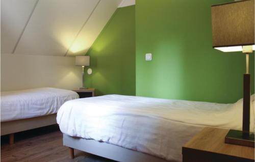 a room with two beds and a green wall at Gentiaan in Ommen