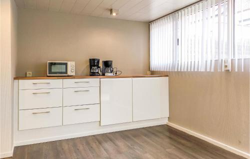 a kitchen with white cabinets and a microwave at 3 Bedroom Pet Friendly Home In Bredene in Bredene