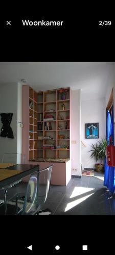 a dining room with a table and a book shelf at Land Scape guesthouse in Eeklo