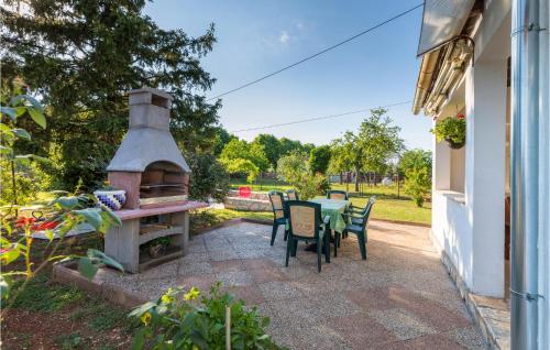 patio ze stołem, krzesłami i piekarnikiem na świeżym powietrzu w obiekcie 2 Bedroom Awesome Home In Vodnjan w mieście Vodnjan
