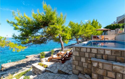 a house with a swimming pool next to the water at Beautiful Home In Prigradica in Prigradica