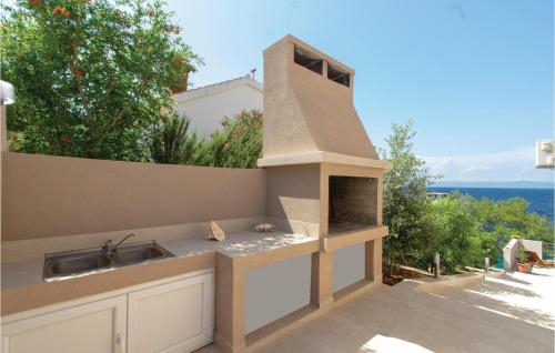 a outdoor kitchen with a sink and an outdoor oven at Beautiful Home In Prigradica in Prigradica