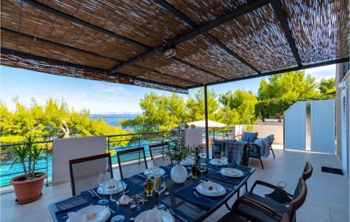 a dining table on a patio with a view of the ocean at Beautiful Home In Prigradica in Prigradica