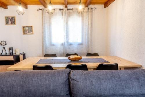 een woonkamer met een houten tafel en een bank bij La Pedrera in Beceite