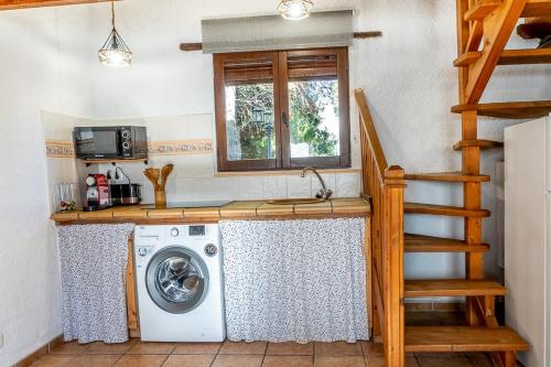 eine Küche mit Waschmaschine und Fenster in der Unterkunft La Pedrera in Beceite