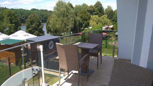 a balcony with a table and chairs overlooking a river at Tófény Őrségi Vendégház in Zalalövő