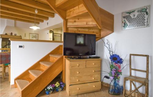 a living room with a staircase with a tv on a dresser at Casa Giglio Rosso in Sovramonte