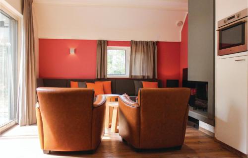 a living room with orange walls and chairs and a table at Reehut in Ommen