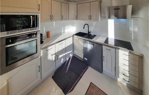 une cuisine avec des armoires blanches et un évier dans l'établissement Pet Friendly Home In Moëlan-Sur-Mer, à Moëlan-sur-Mer