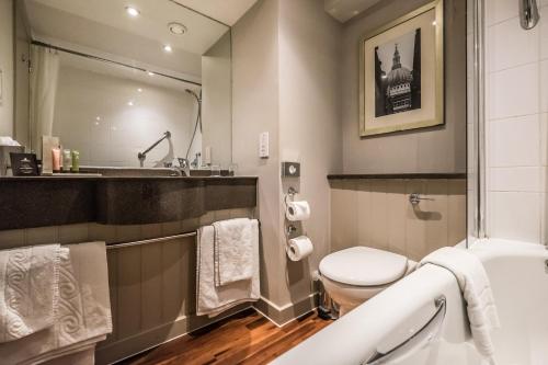 a bathroom with a toilet and a sink at Bridge Hotel in Greenford