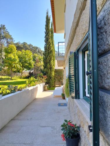 a door to a house with flowers in a courtyard at Casa do Passal in Belinho