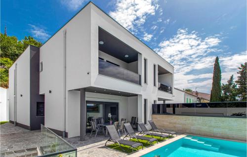 a modern house with a swimming pool and a house at Gorgeous Home In Dramalj in Dramalj