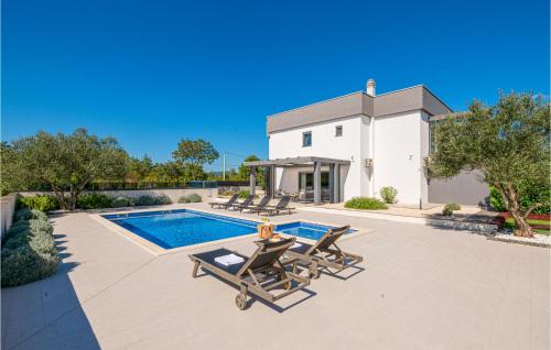 - une piscine avec 2 chaises longues et une maison dans l'établissement Lovely Home In Poljica With Sauna, à Poljica