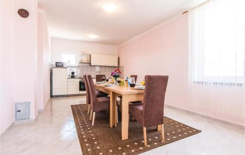 a kitchen and dining room with a table and chairs at Three-Bedroom Apartment In Slivnica in Slivnica