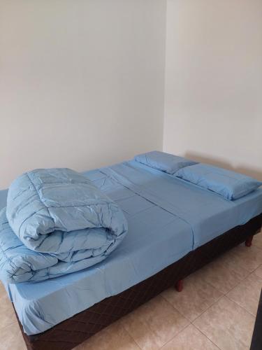 a bed with blue comforter and pillows on it at Lauquen in Puerto Deseado