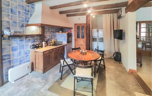 une cuisine avec une table et des chaises dans une pièce dans l'établissement Lovely Home In Cazouls-Lès-Béziers, à Cazouls-lès-Béziers