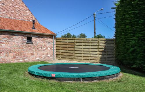 a green trampoline in a yard next to a house at Amazing Home In Diksmuide With Wifi in Diksmuide