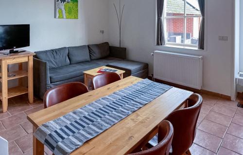 a living room with a table and a couch at Amazing Home In De Moer in De Moer