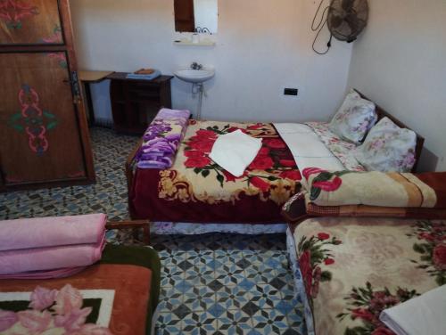 a hotel room with two beds and a sink at Auberge Restaurant Rooftop Tamazirt in Boumalne
