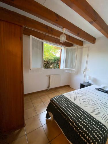 une chambre avec un lit et une fenêtre dans l'établissement Maison à 800m de la plage classée 1 étoile, à Capbreton