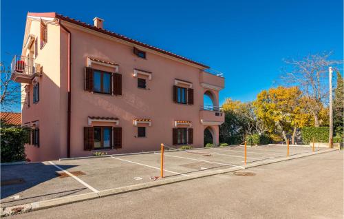 a building with a tennis court in front of it at Stunning Apartment In Njivice With Wifi in Njivice