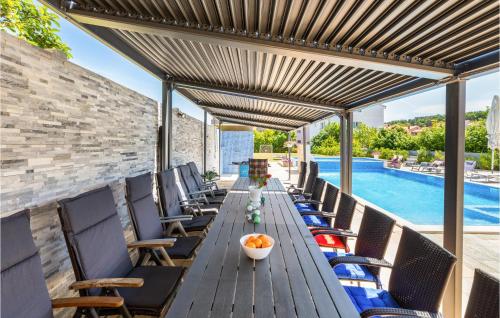 an outdoor patio with a long wooden table and chairs at Beautiful Home In Pula With Jacuzzi in Vintijan