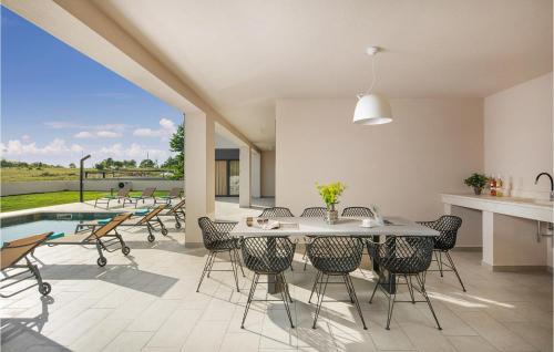 comedor con mesa, sillas y piscina en Awesome Home In Jurazini With Sauna, en Nedeščina