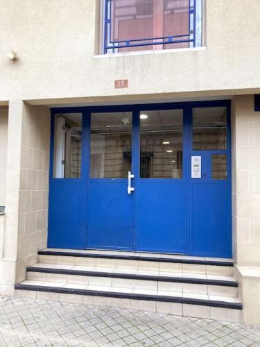 une porte bleue sur le côté d'un bâtiment dans l'établissement Studio SUNSET TERRASSE !, à Bordeaux