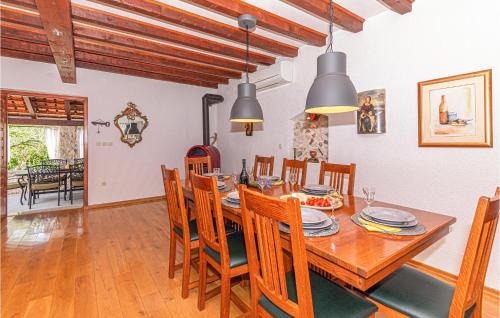 a dining room with a wooden table and chairs at Three-Bedroom Holiday Home In Lozovac in Lozovac