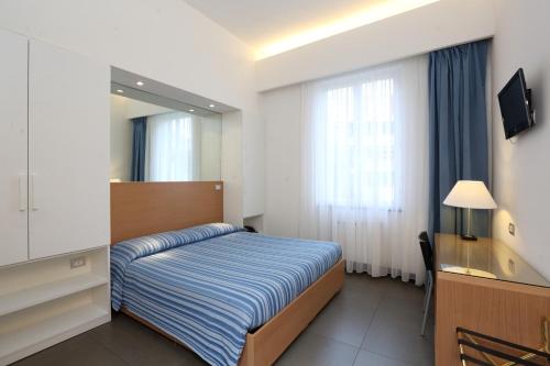 Habitación de hotel con cama y espejo en Hotel Genova, en Sestri Levante