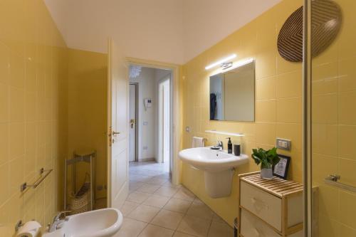 a yellow bathroom with a sink and a mirror at [Near the port]-Elegante appartamento con vista sui canali in Livorno
