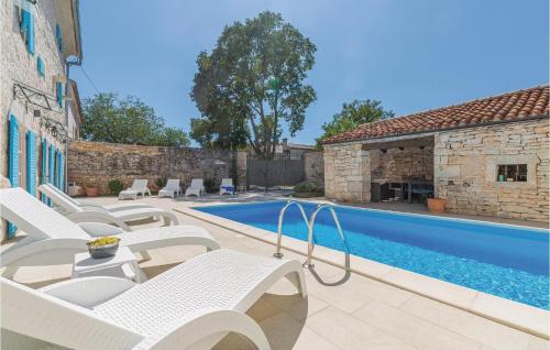 a patio with white chairs and a swimming pool at Four-Bedroom Holiday Home In Kringa in Kringa